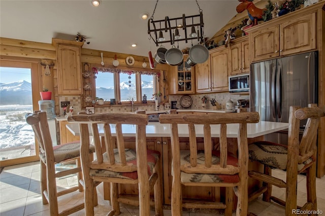 kitchen featuring a mountain view, light tile patterned floors, backsplash, and appliances with stainless steel finishes