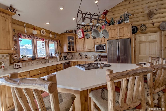 kitchen featuring a breakfast bar, lofted ceiling, sink, decorative backsplash, and appliances with stainless steel finishes