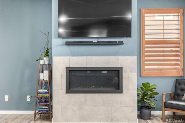 details featuring a fireplace, baseboards, and wood finished floors