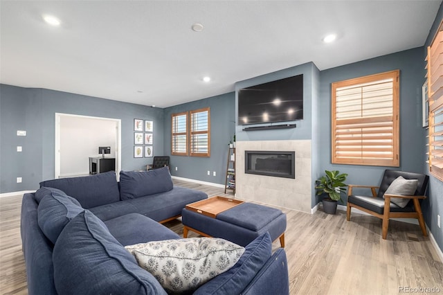 living area with recessed lighting, a fireplace, baseboards, and wood finished floors