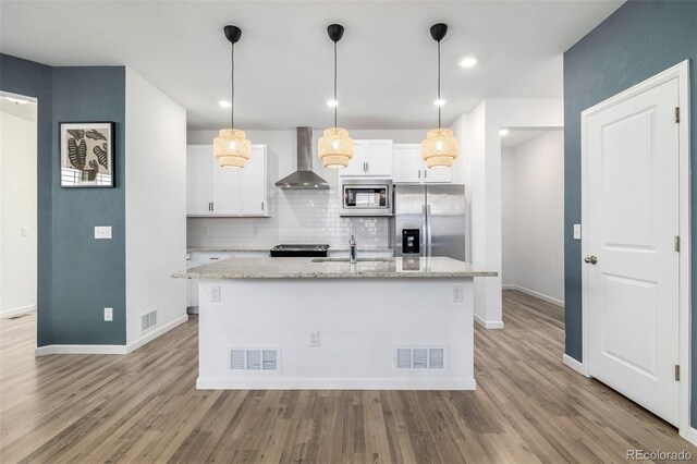 kitchen featuring a sink, visible vents, appliances with stainless steel finishes, and wall chimney range hood