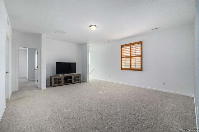 unfurnished living room featuring visible vents, baseboards, and carpet