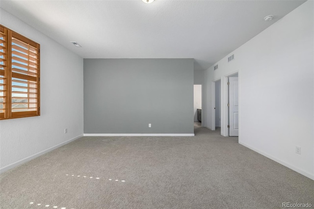 carpeted empty room featuring visible vents and baseboards