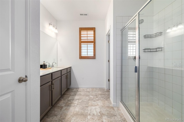 bathroom with visible vents, a shower stall, vanity, and baseboards