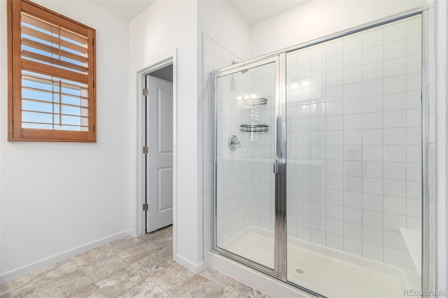 full bathroom featuring baseboards and a shower stall