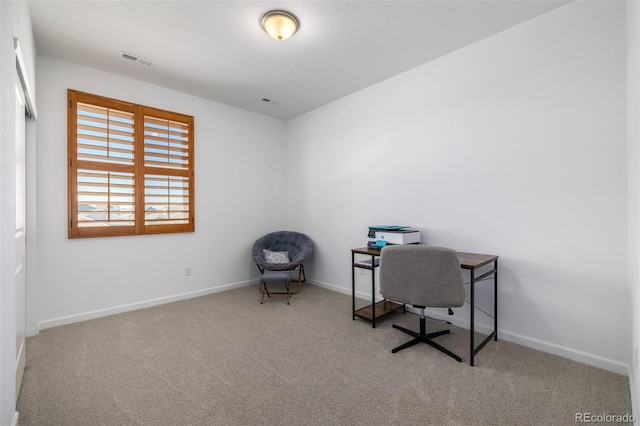 carpeted office featuring visible vents and baseboards