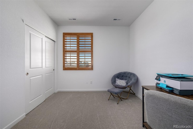 living area with visible vents, baseboards, and carpet flooring