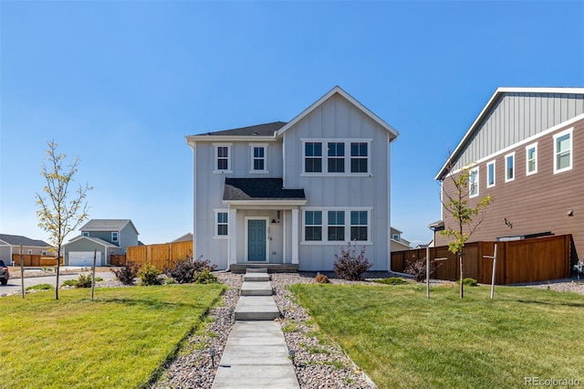 view of front of property with board and batten siding, a shingled roof, a front lawn, and fence