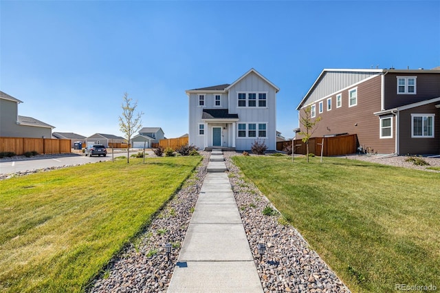 view of front of home featuring a residential view, board and batten siding, a front lawn, and fence