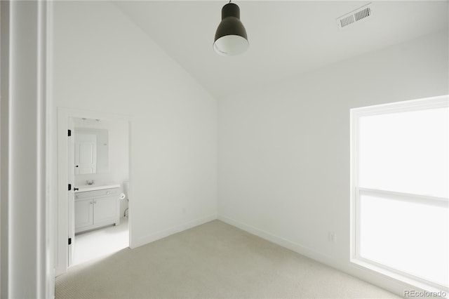 unfurnished room featuring light carpet, baseboards, visible vents, lofted ceiling, and a sink