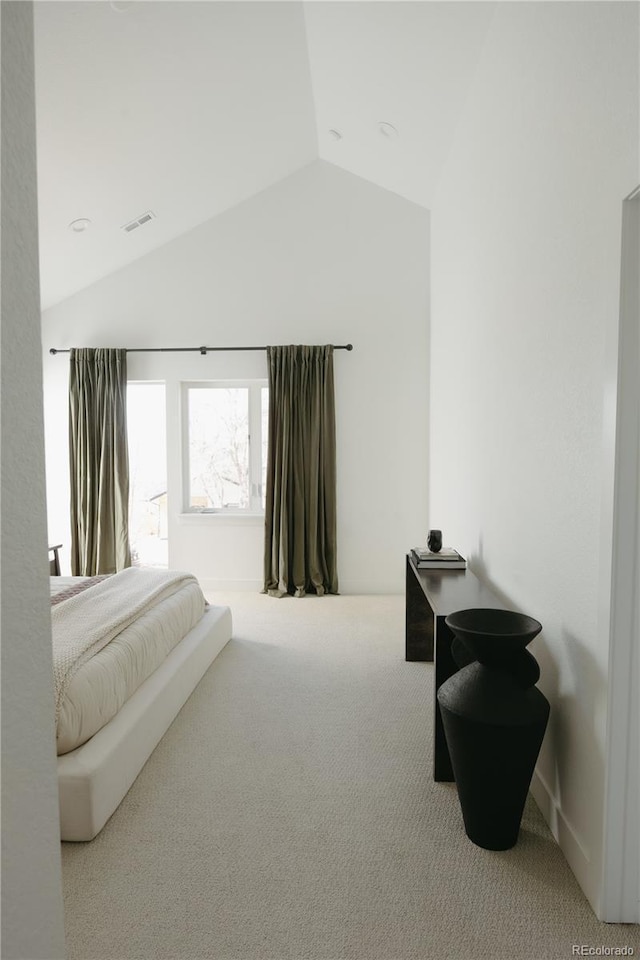 bedroom with lofted ceiling, visible vents, and carpet