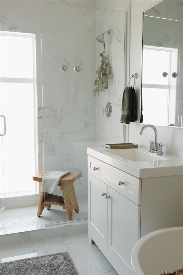 full bath featuring marble finish floor, a marble finish shower, and vanity