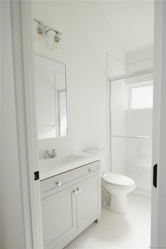 full bathroom featuring toilet, a stall shower, tile patterned flooring, and vanity