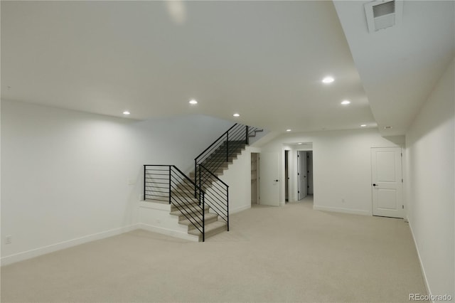 below grade area featuring light carpet, baseboards, visible vents, stairs, and recessed lighting