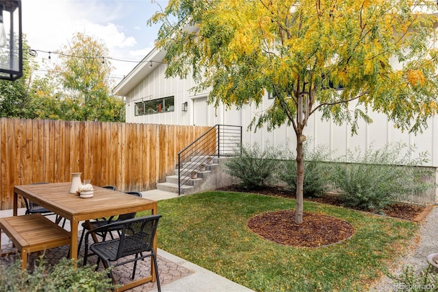 view of yard with outdoor dining space, a patio area, and fence