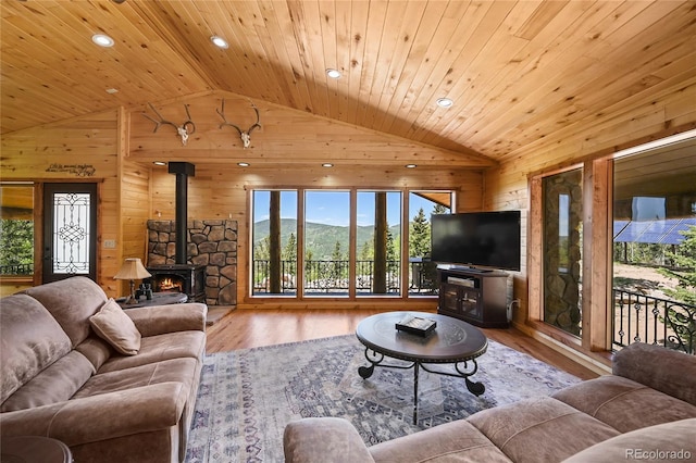 living area featuring vaulted ceiling, wood walls, and wood ceiling