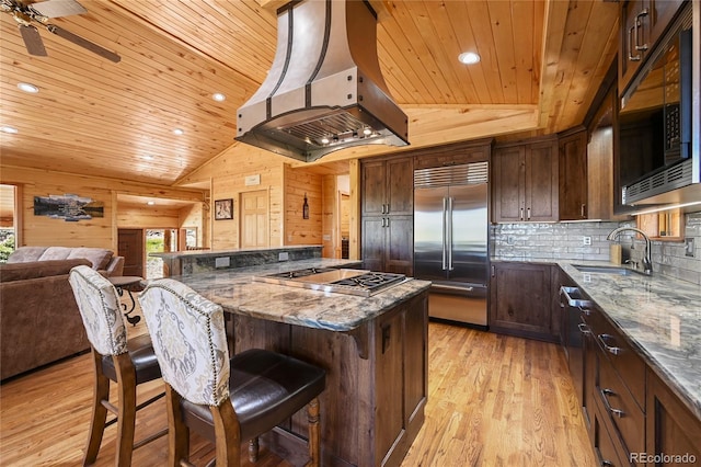 kitchen featuring wood ceiling, ventilation hood, a sink, and built in appliances