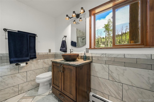 bathroom featuring marble finish floor, tile walls, toilet, a baseboard heating unit, and vanity