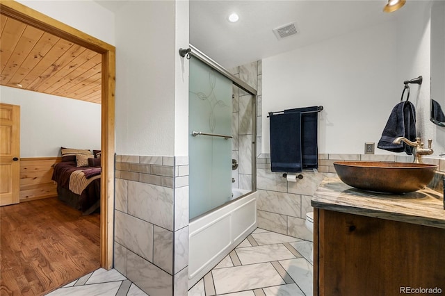 bathroom featuring a wainscoted wall, visible vents, marble finish floor, and tile walls