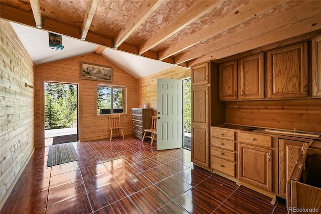 kitchen with brown cabinets, vaulted ceiling with beams, and wood walls