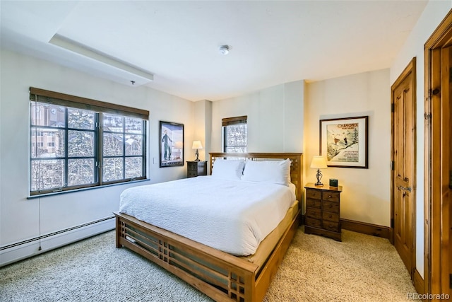 bedroom with a baseboard radiator, light colored carpet, and multiple windows