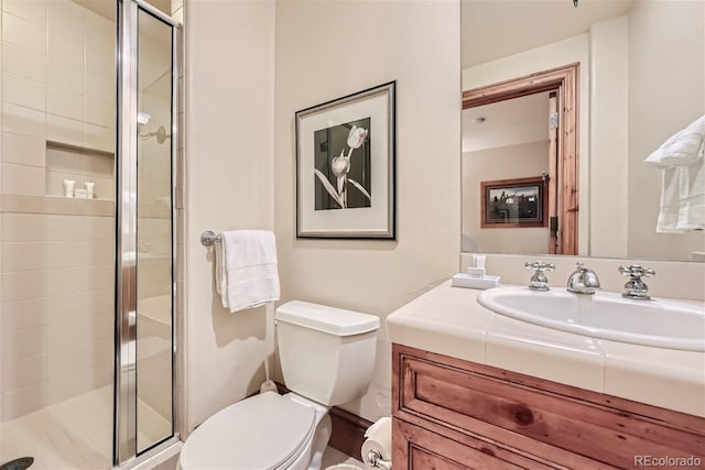 bathroom with walk in shower, vanity, and toilet