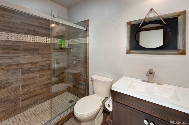 bathroom with vanity, toilet, and a shower with door