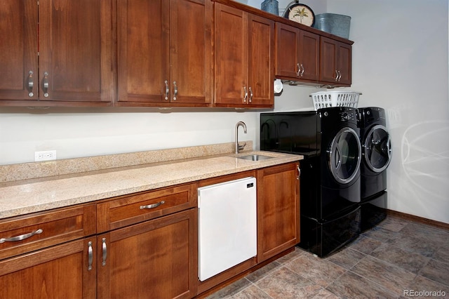 laundry area featuring cabinets, separate washer and dryer, and sink