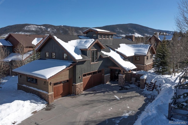 27 Habitat, Dillon, CO 80435 - view of front of home with stone siding, a garage, board and batten siding, a mountain view, and concrete driveway