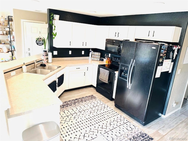 11975 Riverstone Cir Unit 9C, Commerce City, CO 80640 - kitchen featuring light wood finished floors, black appliances, a peninsula, light countertops, and white cabinetry
