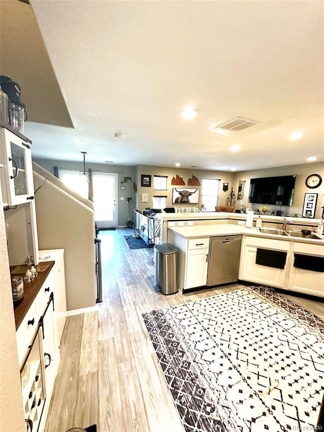 11975 Riverstone Cir Unit 9C, Commerce City, CO 80640 - kitchen featuring open floor plan, healthy amount of natural light, stainless steel dishwasher, light wood-style flooring, and recessed lighting