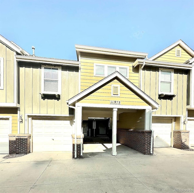 11975 Riverstone Cir Unit 9C, Commerce City, CO 80640 - view of front of property featuring board and batten siding, an attached garage, and driveway