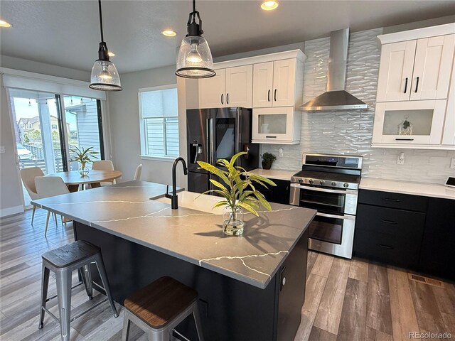 1732 Stable View Dr, Castle Pines, CO 80108 - kitchen with wall chimney range hood, range with two ovens, black fridge, a breakfast bar, and backsplash