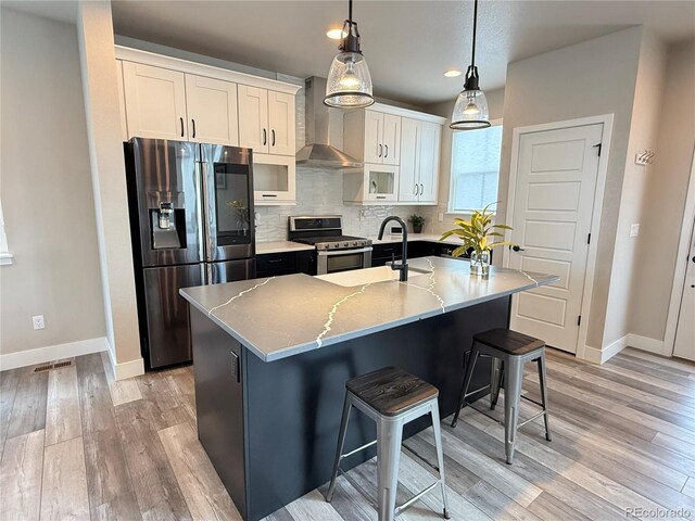1732 Stable View Dr, Castle Pines, CO 80108 - kitchen featuring stainless steel appliances, wall chimney exhaust hood, baseboards, light wood-style flooring, and recessed lighting