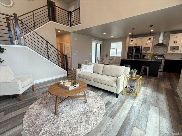1732 Stable View Dr, Castle Pines, CO 80108 - living area featuring stairs, wood finished floors, a towering ceiling, and recessed lighting