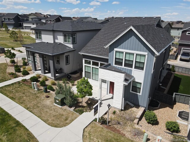 1732 Stable View Dr, Castle Pines, CO 80108 - view of front of property with a residential view, board and batten siding, a shingled roof, a patio, and fence