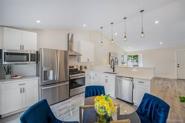11510 Otis St, Westminster, CO 80020 - kitchen featuring stainless steel appliances, wall chimney exhaust hood, a peninsula, backsplash, and white cabinetry