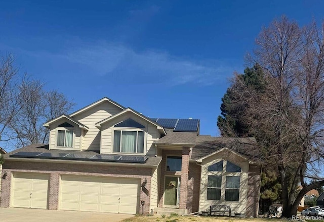 3701 W 98th Pl, Westminster, CO 80031 - view of front of home featuring solar panels, brick siding, an attached garage, and concrete driveway