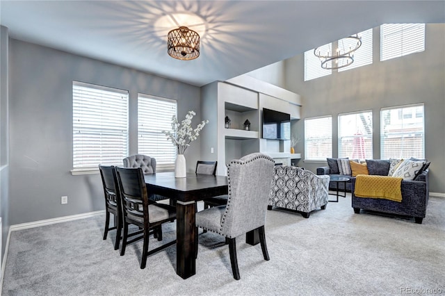 dining space with carpet flooring and a chandelier