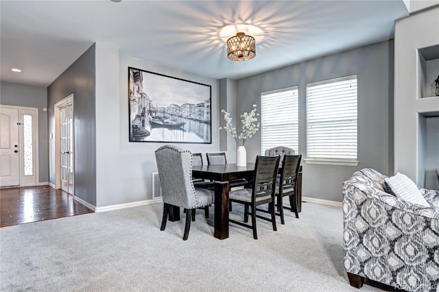 carpeted dining room with an inviting chandelier