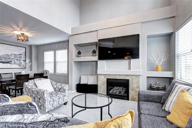 carpeted living room with plenty of natural light and built in features