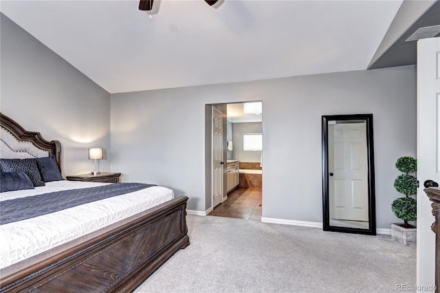 bedroom featuring ceiling fan, connected bathroom, and light carpet