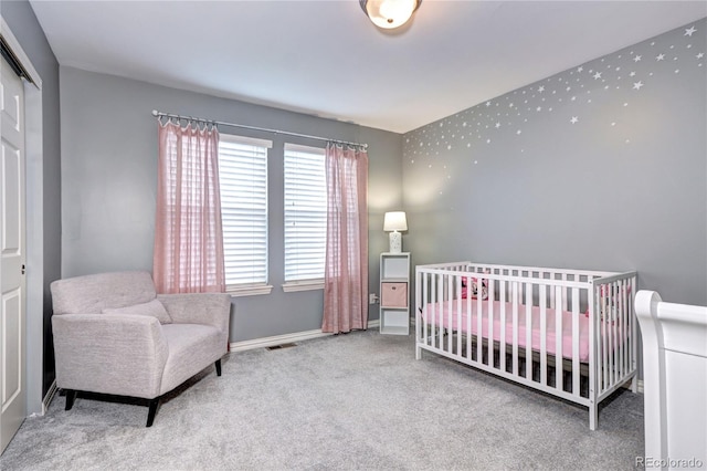 bedroom featuring a closet, a crib, and carpet floors