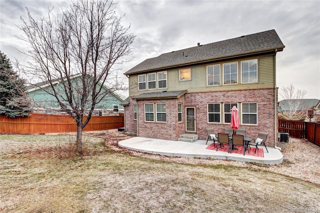 rear view of property featuring a yard, a patio, and central AC