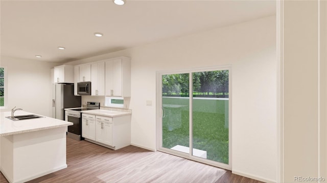 kitchen with white cabinets, stainless steel appliances, sink, light wood-type flooring, and light stone counters