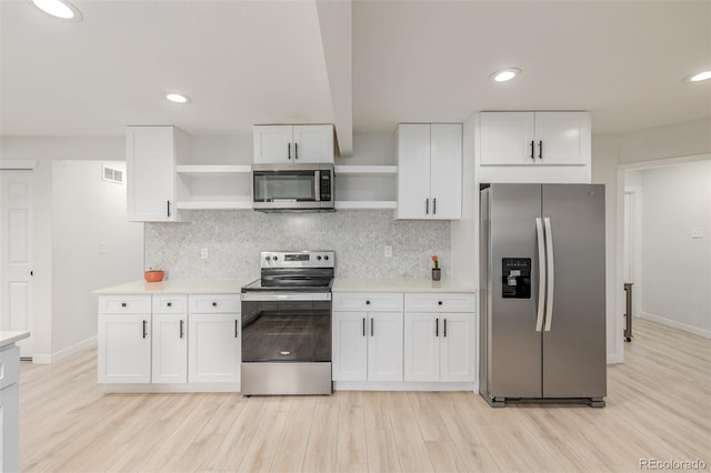 7752 Meade St, Westminster, CO 80030 - kitchen with appliances with stainless steel finishes, open shelves, light wood finished floors, white cabinets, and light countertops