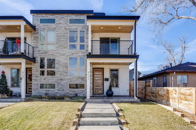 modern home featuring a balcony and a front lawn