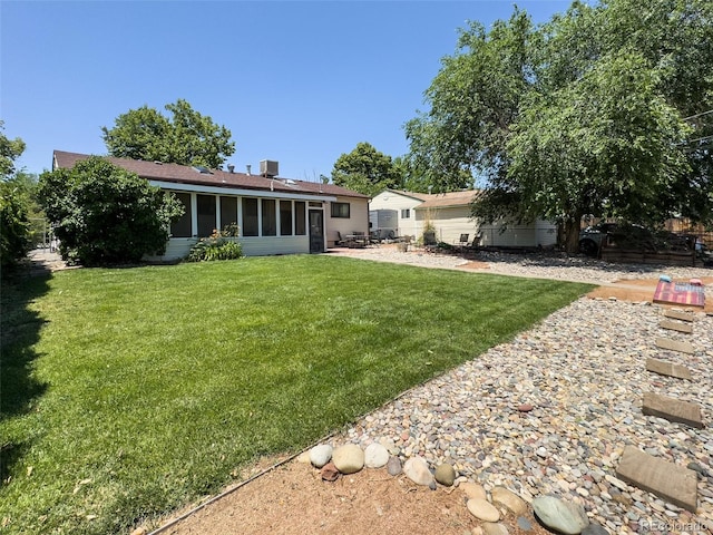 2114 N 21st St, Grand Junction, CO 81501 - rear view of house with a sunroom, a lawn, roof with shingles, and a patio