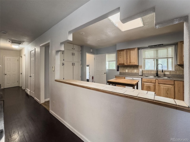2114 N 21st St, Grand Junction, CO 81501 - kitchen featuring dishwasher, dark wood-style floors, decorative backsplash, and a peninsula