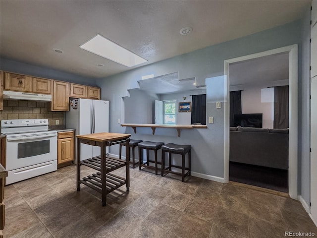 2114 N 21st St, Grand Junction, CO 81501 - kitchen with white appliances, under cabinet range hood, a skylight, and decorative backsplash